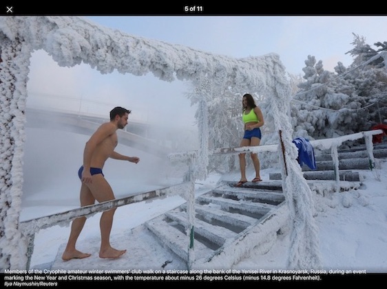 Members of the Cryophile amateur winter swimmers' club walk on a staircase along the bank of the Yenisei River.