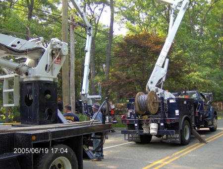 Photo of three power company trucks responding to downed line incident